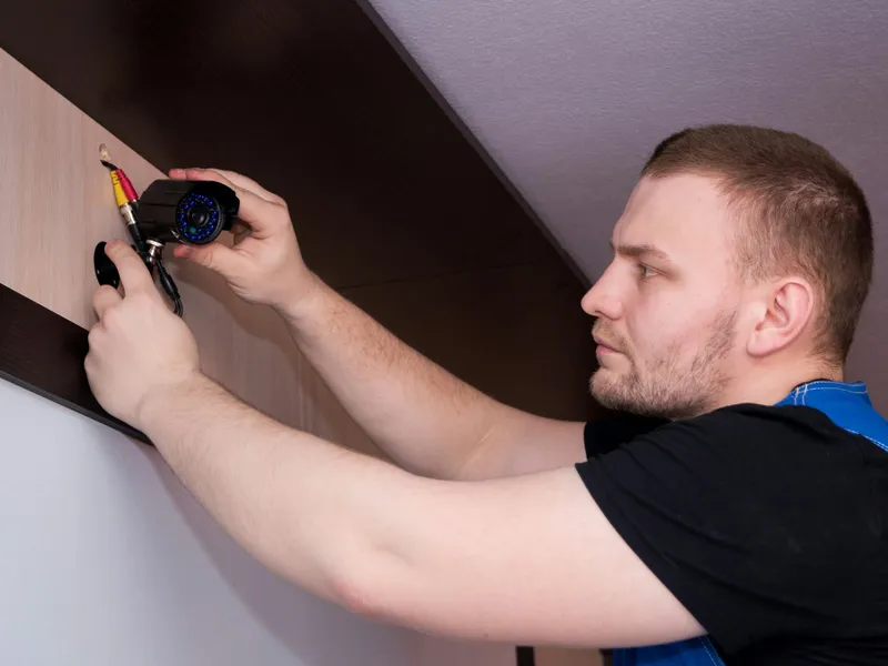 A technician fixing a fitting to a wall