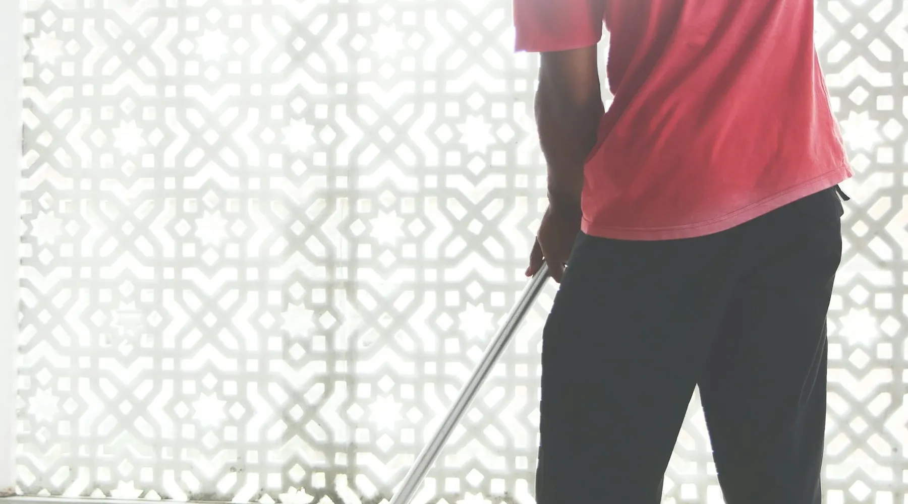 A cleaner mopping a bright office floor