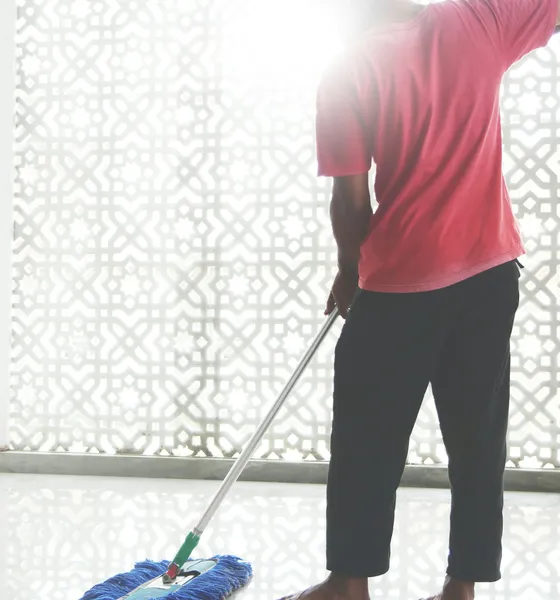 A crew member mopping a bright floor