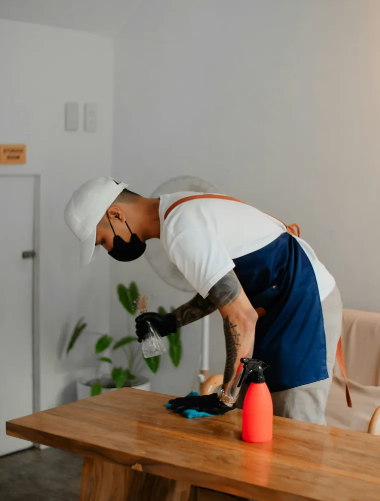 A crew member wiping down a wooden table