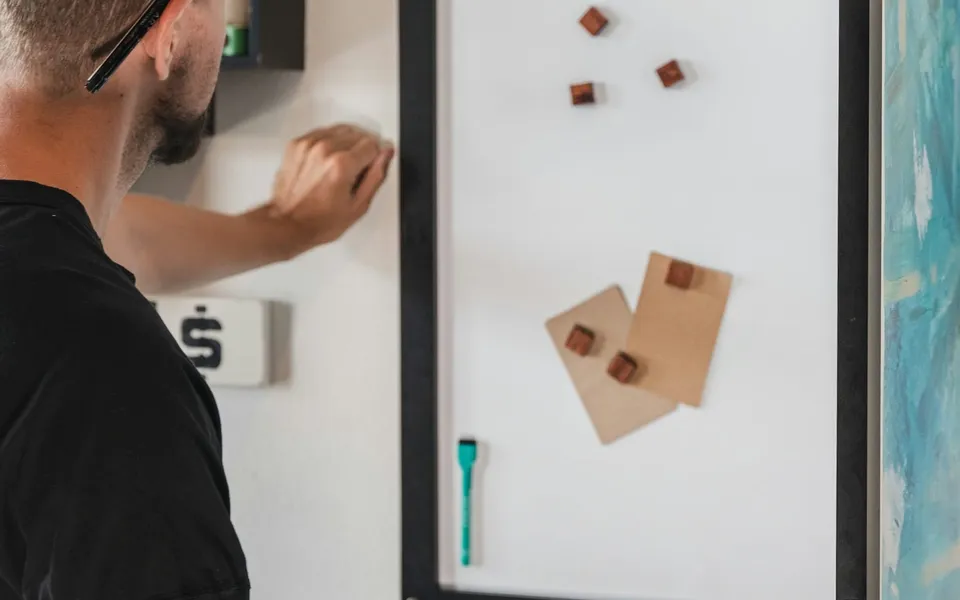 A fitter mounting a board on a wall