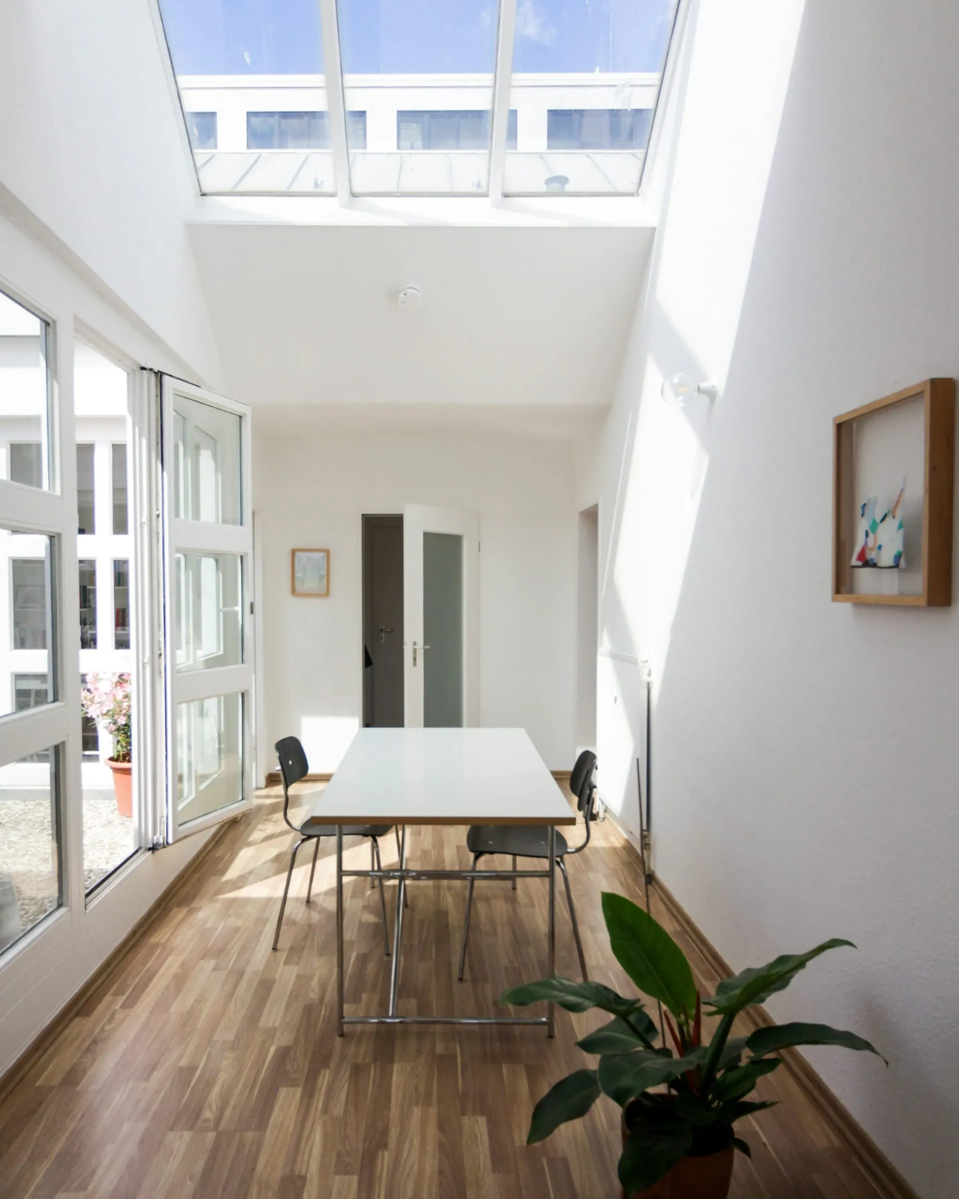 A bright office corridor under a skylight after the evening clean