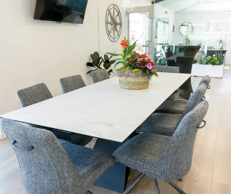 A meeting room with a clean table and chairs pushed in