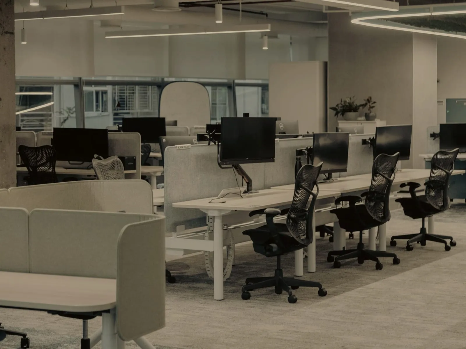 Open-plan office before cleaning: dusty desks, screens, and carpet