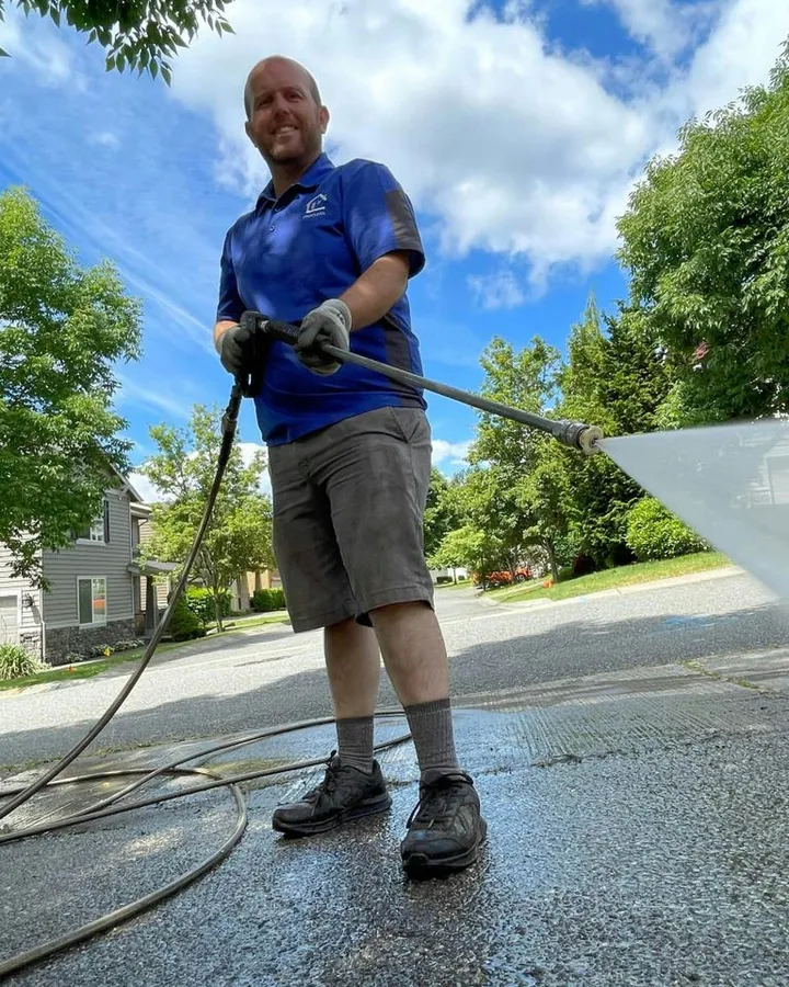 A pro washing a patio with a pressure wand